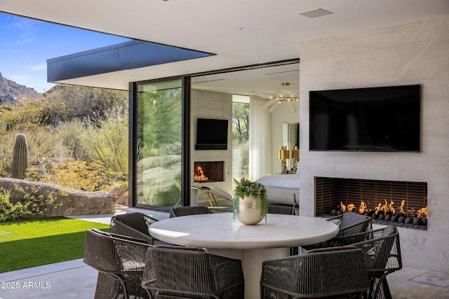 sunroom with an outdoor fireplace, a healthy amount of sunlight, and a mountain view