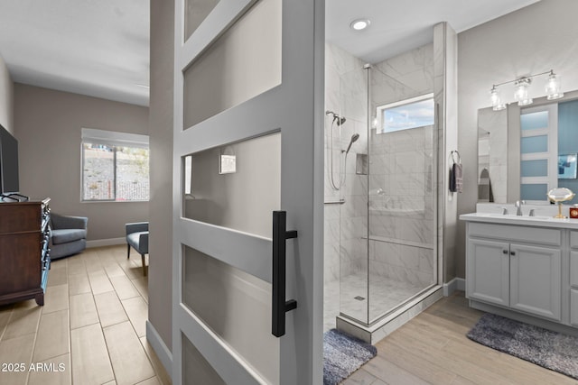 bathroom featuring vanity, wood-type flooring, and a tile shower