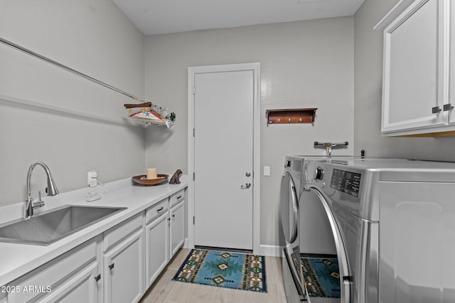 laundry room featuring separate washer and dryer, sink, and cabinets