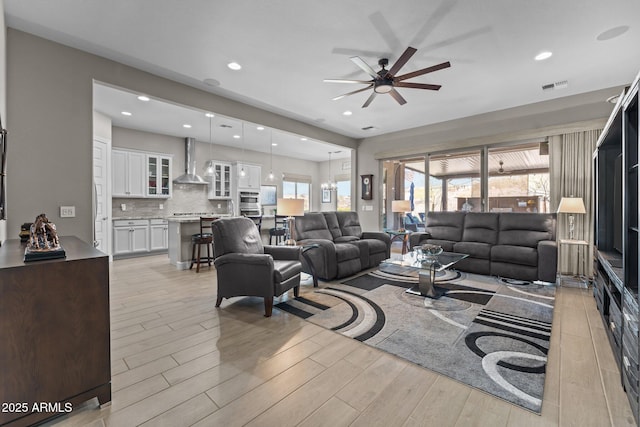 living room featuring ceiling fan and light hardwood / wood-style floors