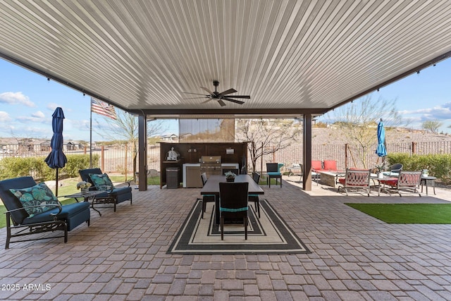 view of patio featuring an outdoor kitchen, area for grilling, an outdoor living space with a fire pit, and ceiling fan