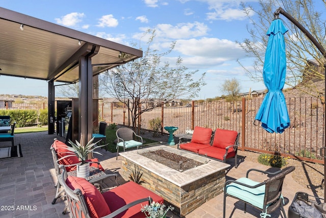 view of patio with an outdoor living space with a fire pit