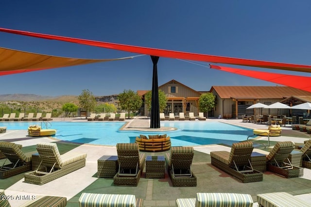 view of swimming pool with a mountain view and a patio area