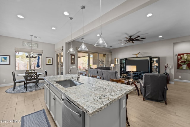 kitchen with sink, dishwasher, pendant lighting, a healthy amount of sunlight, and a kitchen island with sink