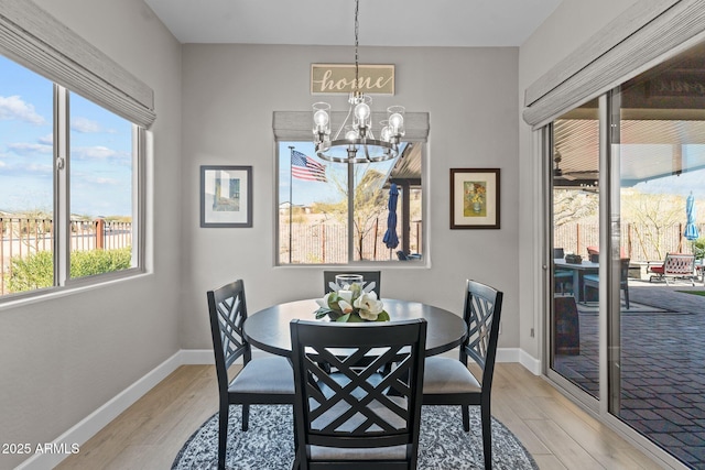 dining space featuring a notable chandelier and light wood-type flooring