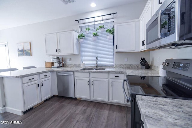 kitchen with white cabinetry, sink, kitchen peninsula, and appliances with stainless steel finishes