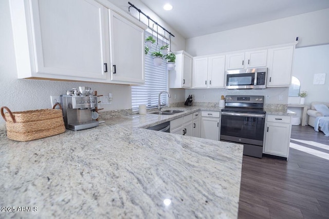 kitchen featuring sink, white cabinetry, light stone counters, appliances with stainless steel finishes, and dark hardwood / wood-style floors