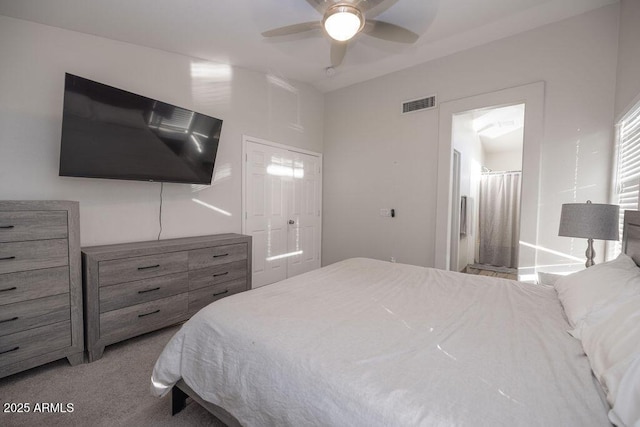 bedroom featuring light carpet, ensuite bath, a closet, and ceiling fan