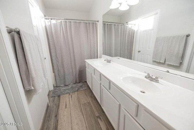 bathroom featuring hardwood / wood-style flooring, vanity, and walk in shower