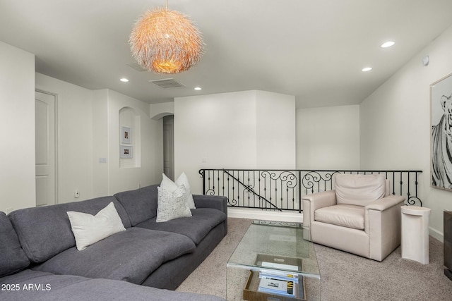 carpeted living area featuring recessed lighting, visible vents, and arched walkways