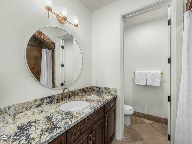 bathroom featuring baseboards, vanity, and toilet