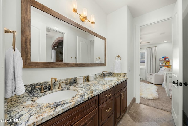 bathroom featuring a sink, baseboards, and double vanity