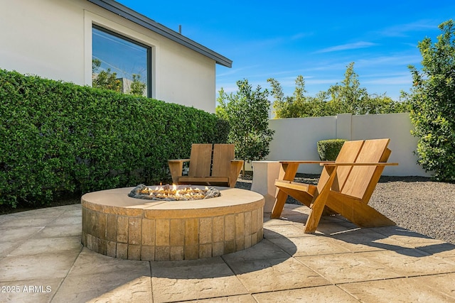 view of patio / terrace with a fire pit and fence