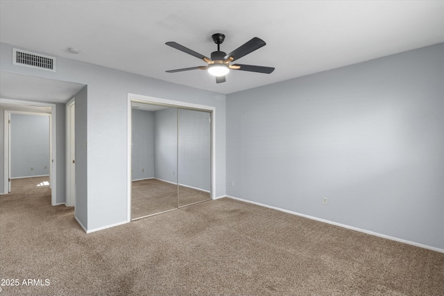 unfurnished bedroom with a closet, ceiling fan, and carpet