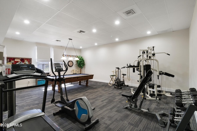 exercise room featuring a paneled ceiling and dark carpet