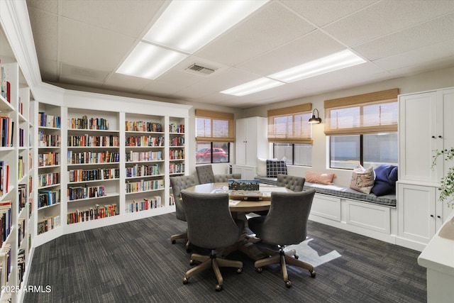 office space featuring a paneled ceiling and dark carpet