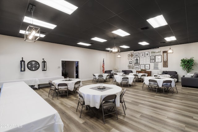 dining space featuring wood-type flooring and a paneled ceiling