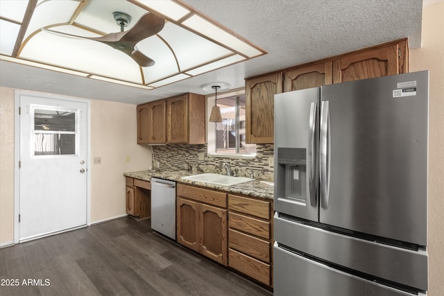 kitchen with appliances with stainless steel finishes, pendant lighting, sink, dark hardwood / wood-style flooring, and decorative backsplash