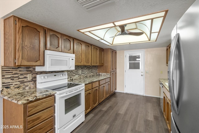 kitchen featuring tasteful backsplash, dark hardwood / wood-style flooring, light stone countertops, and white appliances