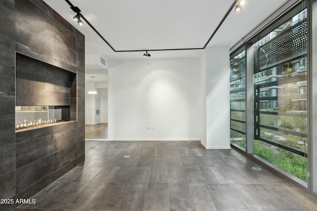 unfurnished living room featuring rail lighting and a fireplace