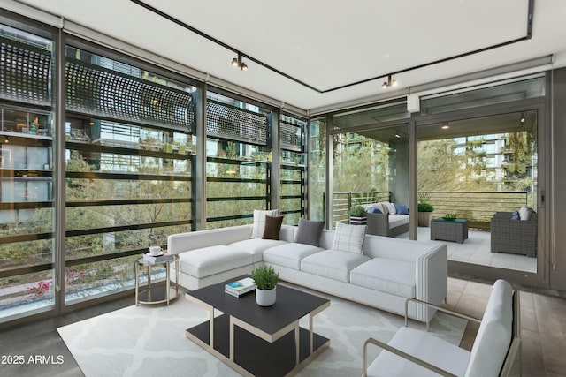 sunroom / solarium featuring rail lighting