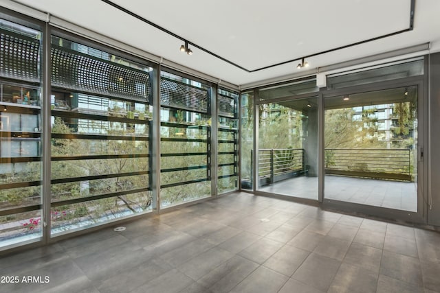 interior space featuring rail lighting and a wall of windows