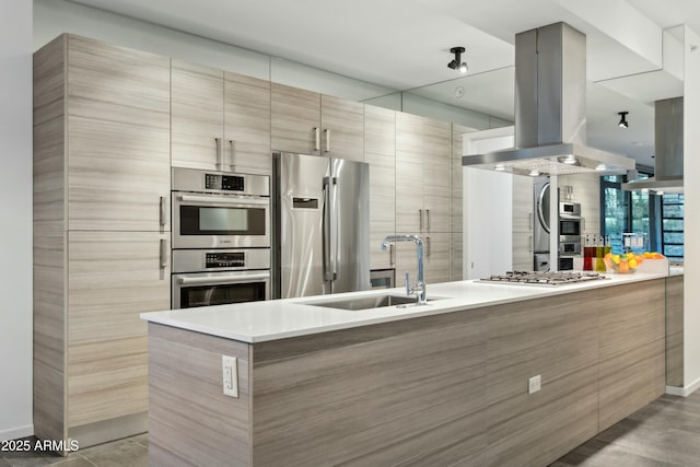 kitchen with island exhaust hood, appliances with stainless steel finishes, sink, and kitchen peninsula