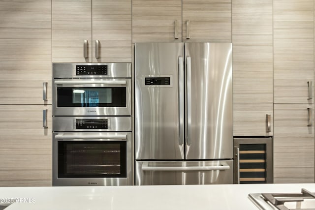 kitchen featuring stainless steel appliances, light brown cabinets, and wine cooler