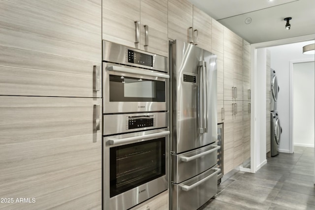 kitchen featuring stainless steel appliances and stacked washer / dryer