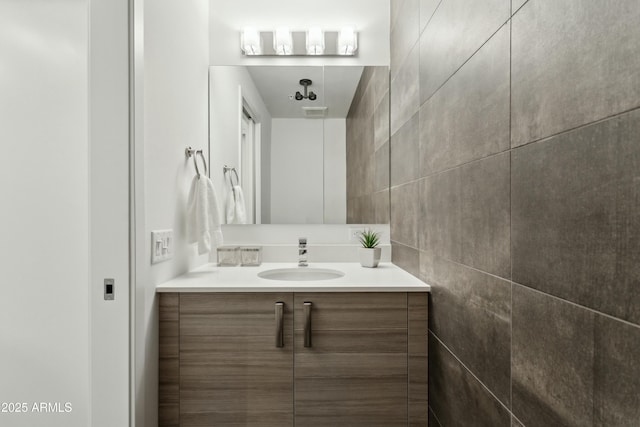 bathroom with vanity and tile walls