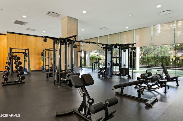 gym with wooden walls and a wall of windows