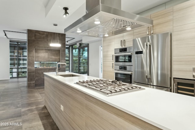 kitchen with wine cooler, sink, hanging light fixtures, island exhaust hood, and stainless steel appliances