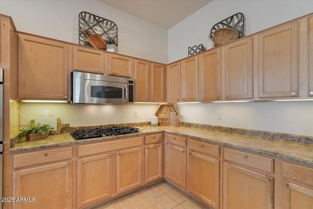 kitchen featuring black gas stovetop, light tile patterned floors, and light brown cabinetry