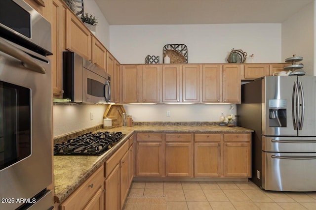 kitchen with light brown cabinetry, light stone countertops, light tile patterned floors, and stainless steel appliances