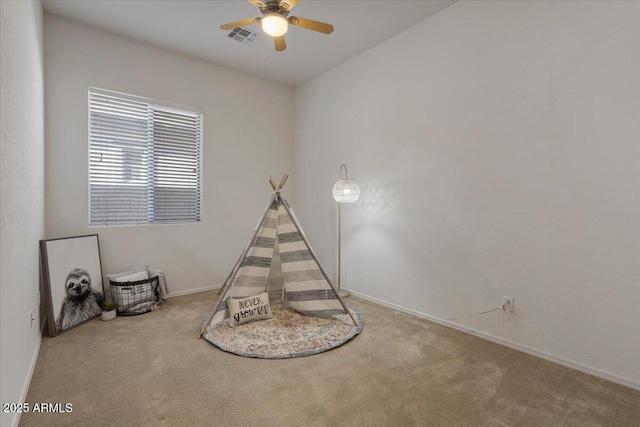 playroom with ceiling fan and light colored carpet