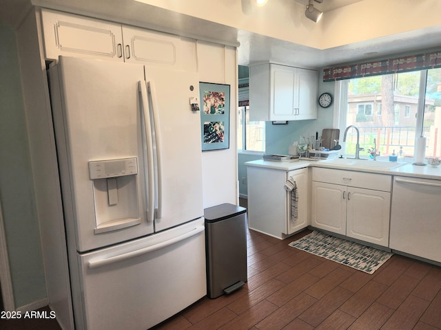 kitchen with white cabinetry, white appliances, and sink