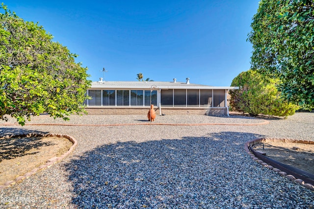 rear view of house featuring a sunroom