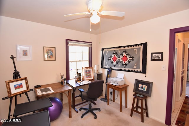 carpeted home office featuring ceiling fan