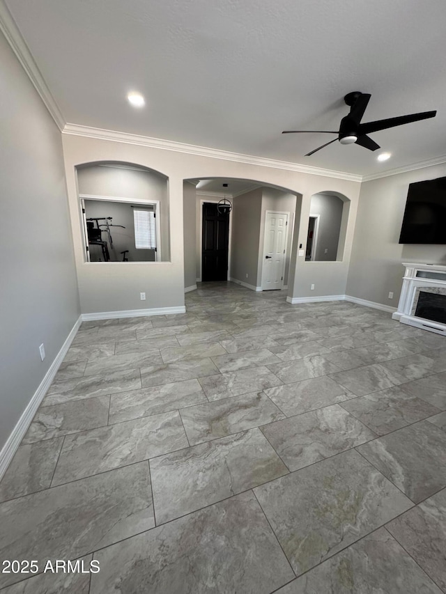 unfurnished living room with ceiling fan and ornamental molding