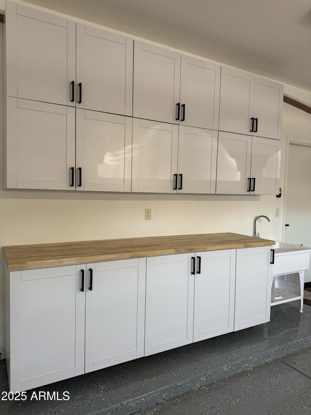 interior space featuring wood counters and white cabinetry