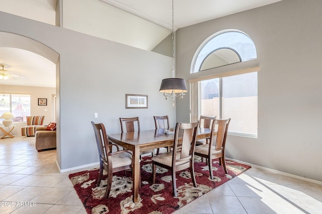 dining area featuring ceiling fan, vaulted ceiling, and light tile patterned floors