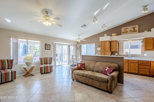 tiled living room with lofted ceiling, ceiling fan, and sink