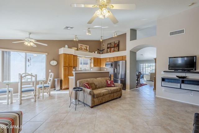 living room featuring lofted ceiling, ceiling fan, and light tile patterned floors