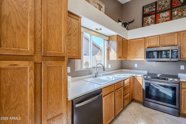 kitchen with appliances with stainless steel finishes, light tile patterned flooring, and sink