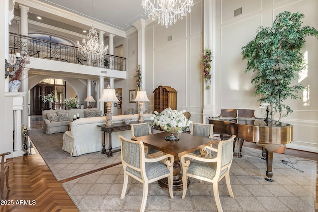 9451 E Happy Valley Rd, Scottsdale, AZ 85255 - dining space featuring a towering ceiling, an inviting chandelier, visible vents, ornamental molding, and a decorative wall