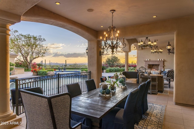 9451 E Happy Valley Rd, Scottsdale, AZ 85255 - dining room with arched walkways, an inviting chandelier, a warm lit fireplace, and recessed lighting