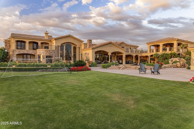 9451 E Happy Valley Rd, Scottsdale, AZ 85255 - back of house with stucco siding, stone siding, a chimney, and a yard