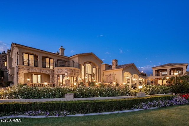 9451 E Happy Valley Rd, Scottsdale, AZ 85255 - back of house with stone siding, a chimney, a balcony, and stucco siding