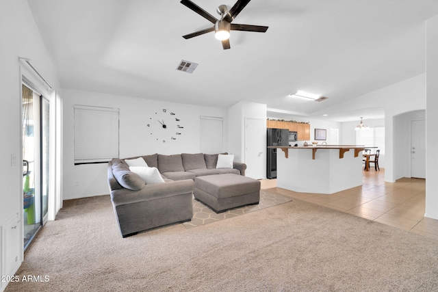 16887 W Belleview St, Goodyear, AZ 85338 - living area featuring healthy amount of natural light, light carpet, vaulted ceiling, light tile patterned flooring, and ceiling fan