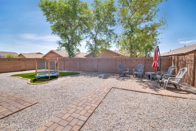 16887 W Belleview St, Goodyear, AZ 85338 - fenced backyard featuring a trampoline and a patio